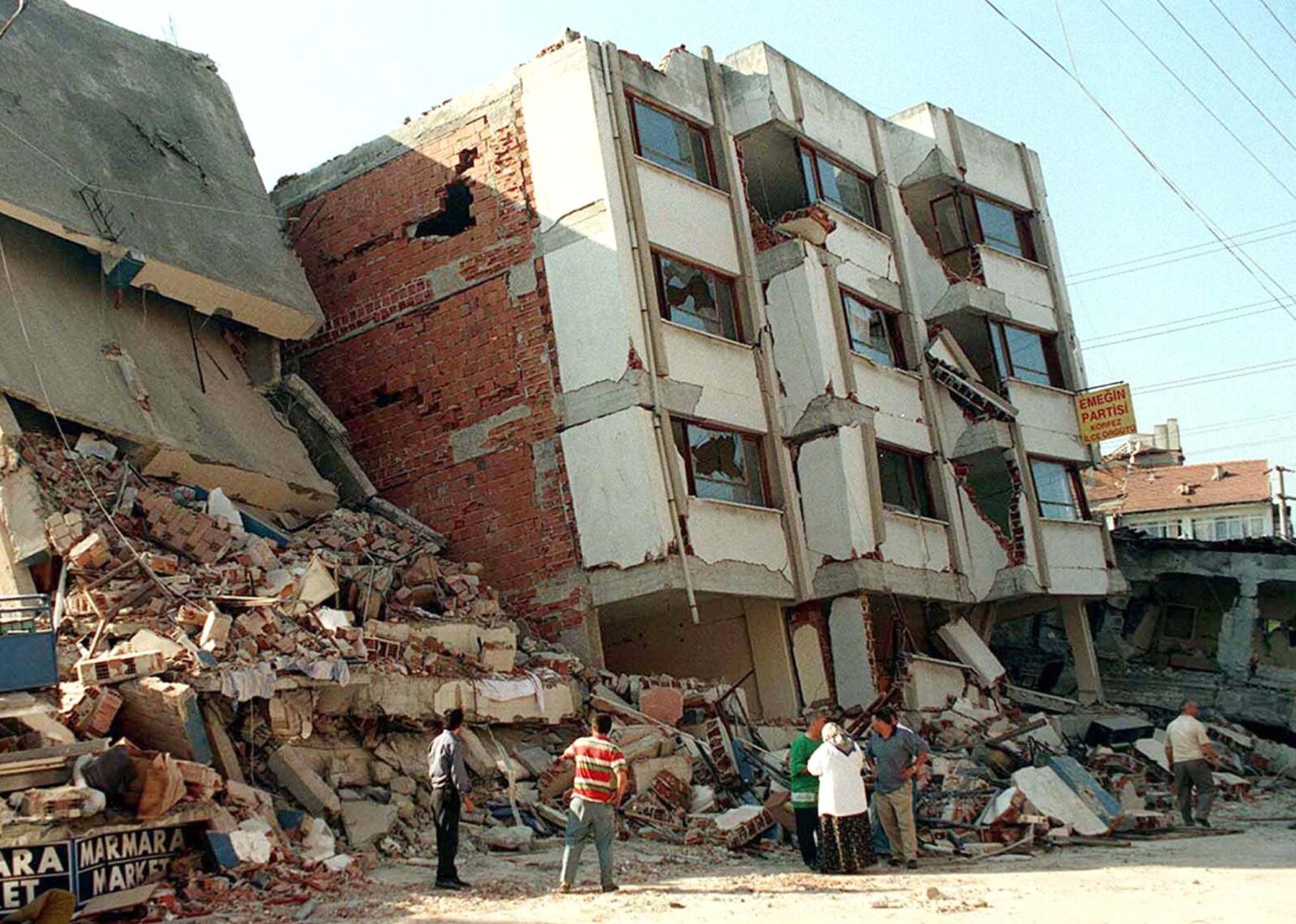 People inspect the wreckage of houses in Izmit, in the aftermath of an earthquake, measuring 7.8 Richter scale,