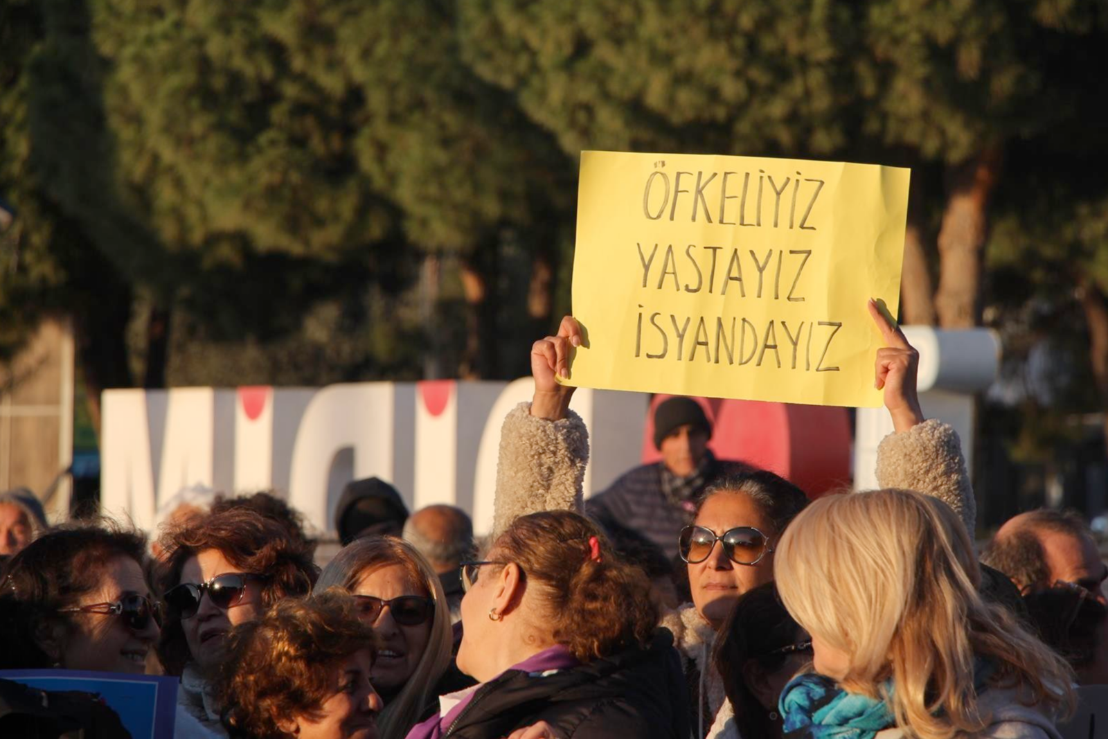 An woman holds a sign that reads, 