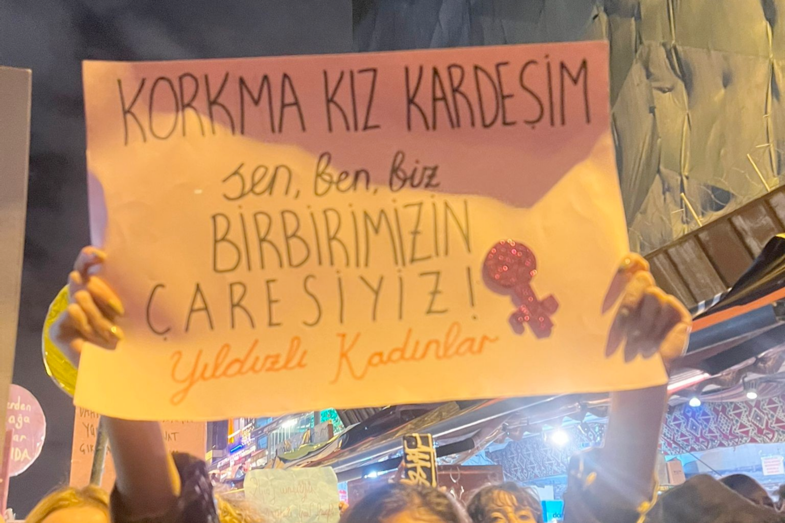 A sign held by protesters reads, 
