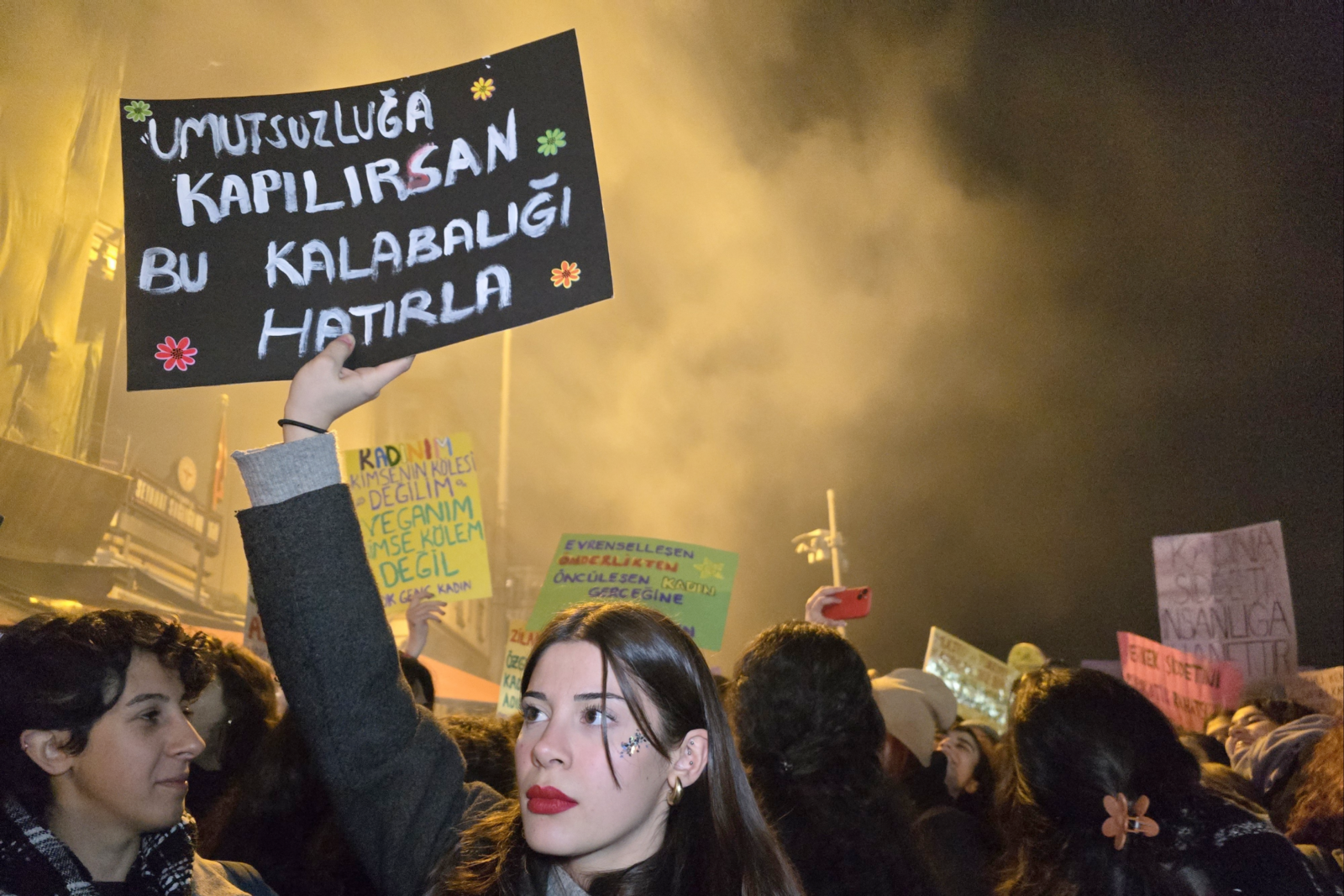 A protester holds up a sign reading, 