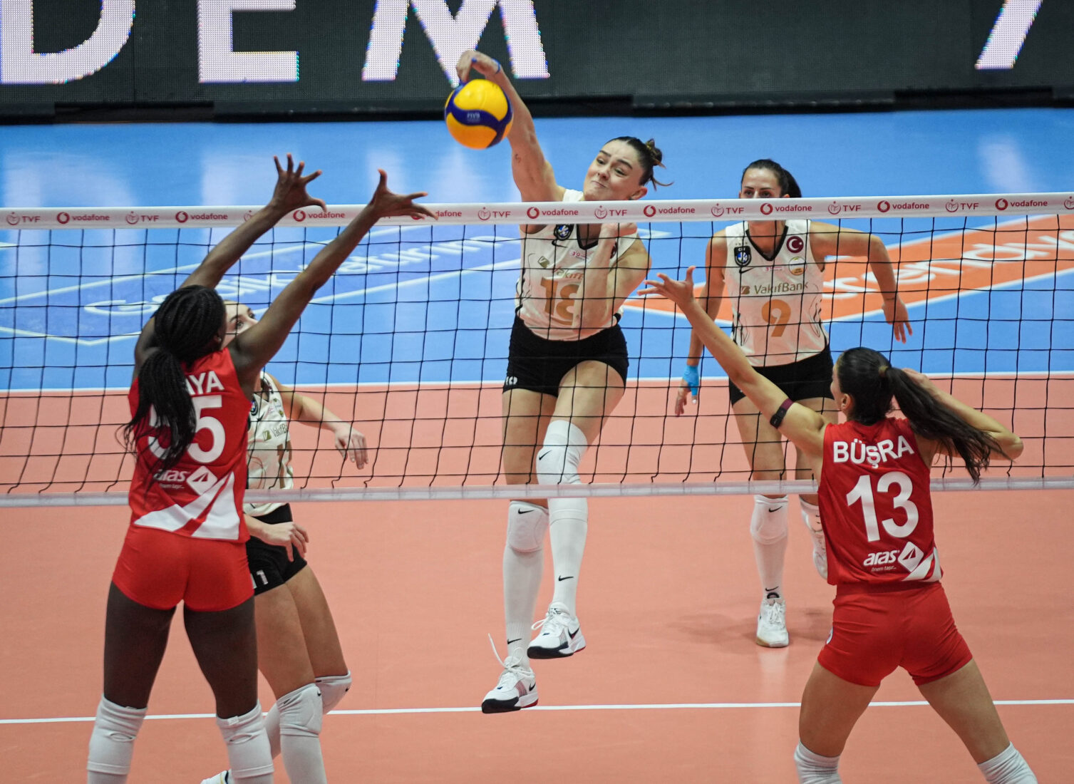 Karina Olaya (55) and Busra Gunes (13) compete at the net with VakifBank
