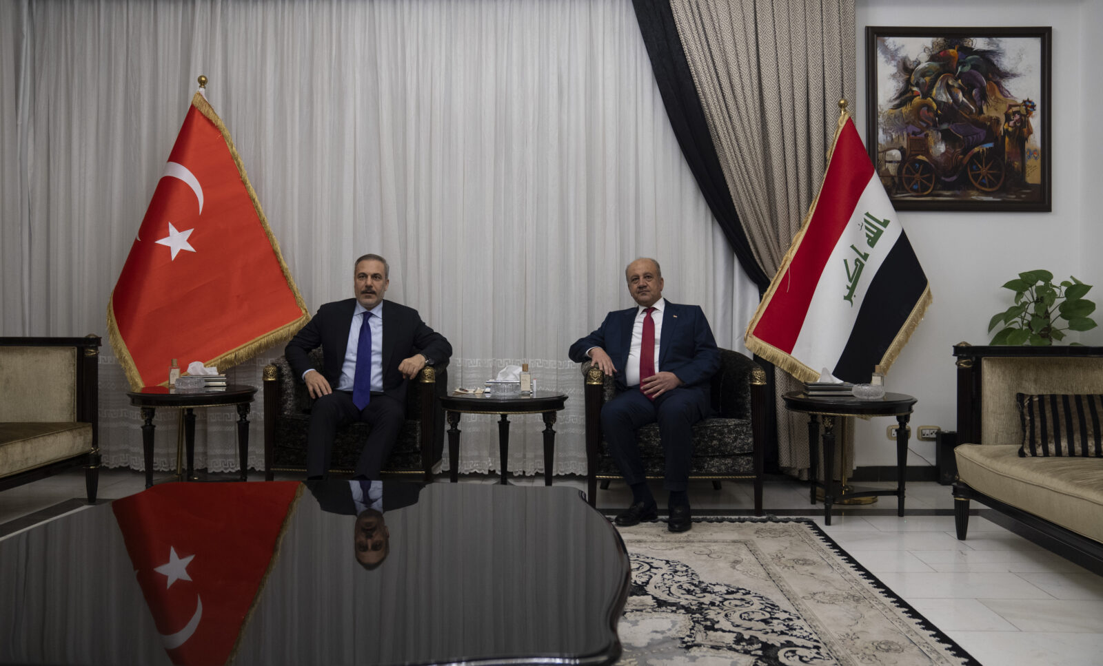 Photo shows Turkey foreign minister hakan fidan sitting beside Iraqi defense minister Abbasi