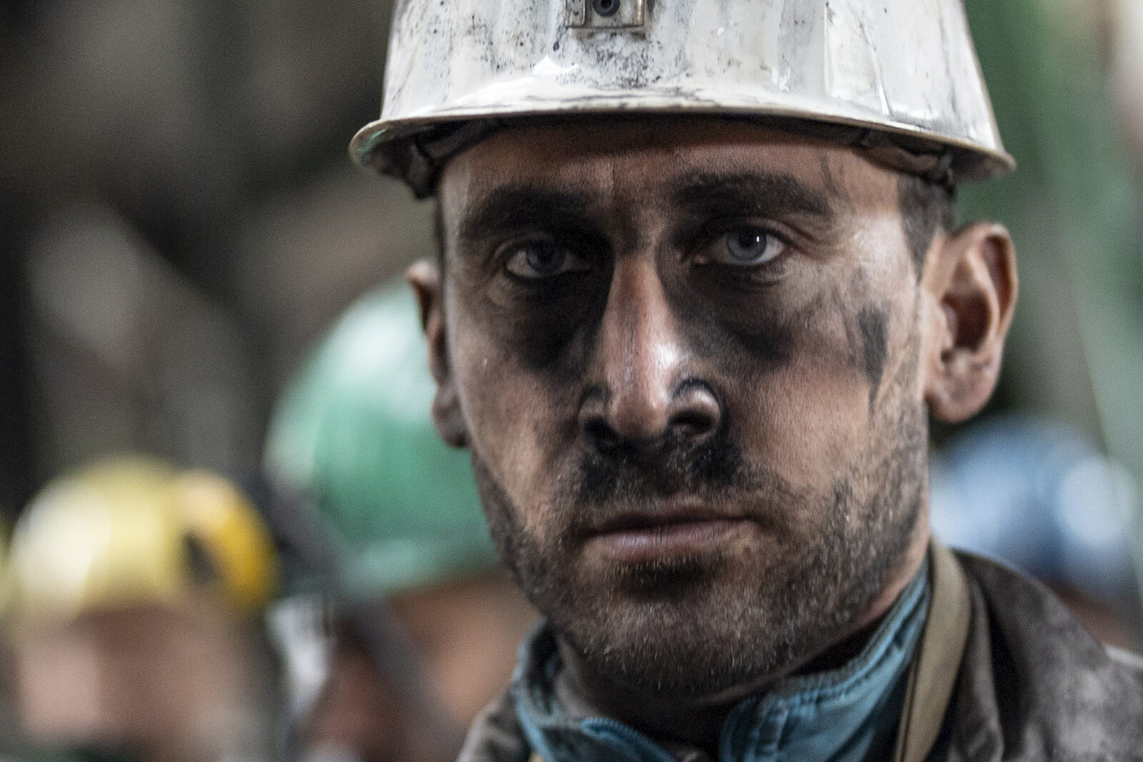 A coal miner with a soot-streaked face looks exhausted as he poses at a mine site in Zonguldak, Türkiye, during World Miners