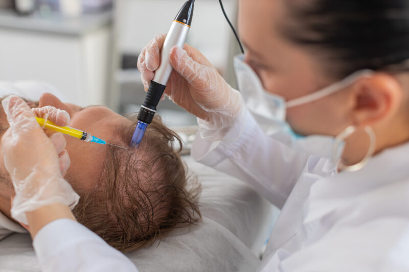 A specialist in a white coat and gloves administers PRP therapy to a patient