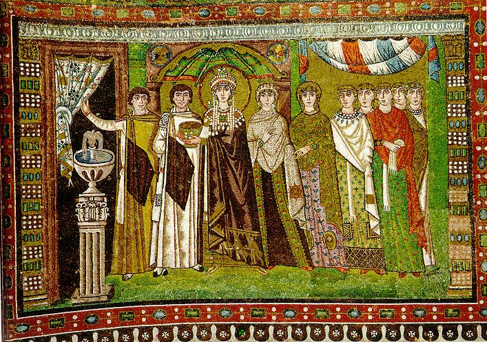 A 6th-century Byzantine mosaic from the Basilica of San Vitale in Ravenna, Italy, showing Empress Theodora standing among her attendants. She wears a richly decorated robe and a halo, signifying her imperial and religious significance. To her left are court officials and clergy, while noblewomen in ornate garments stand on her right. The background features an arched doorway and intricate decorative patterns.