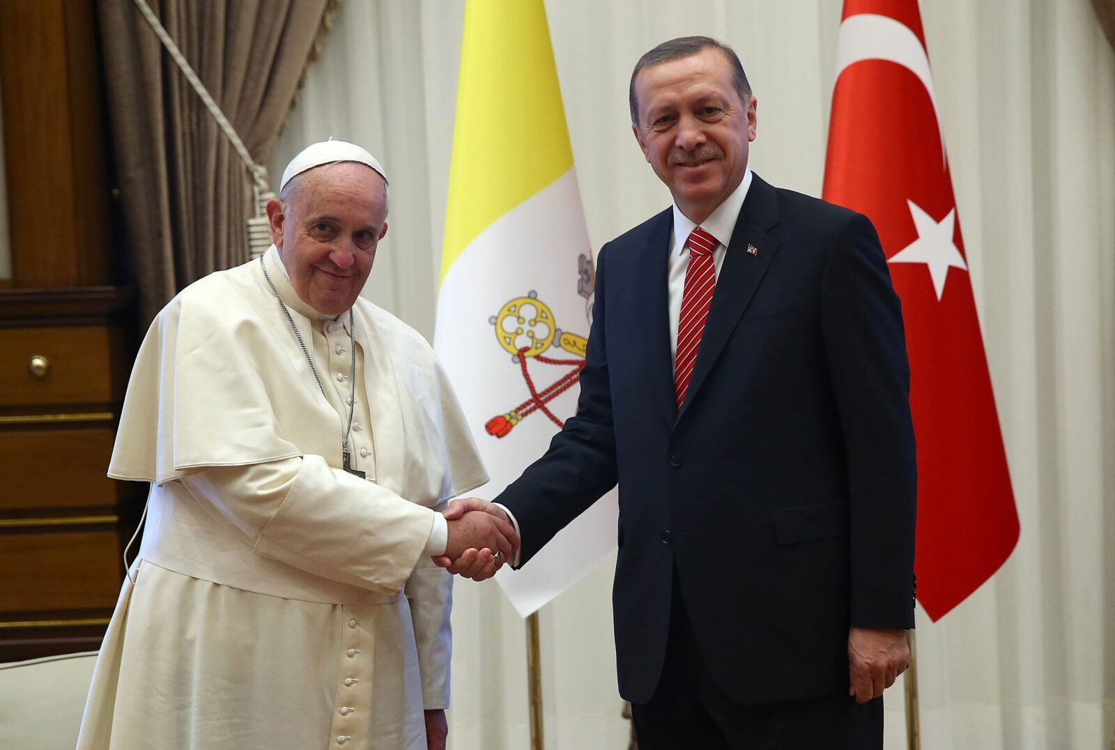 President Recep Tayyip Erdogan (R) and Pope Francis shake hands