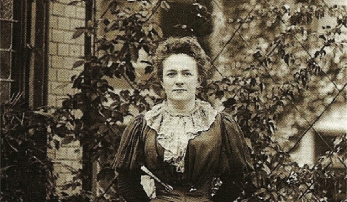 International Women Day - Clara Zetkin in 1897, standing outdoors in a dark dress with lace details, known for her contributions to women