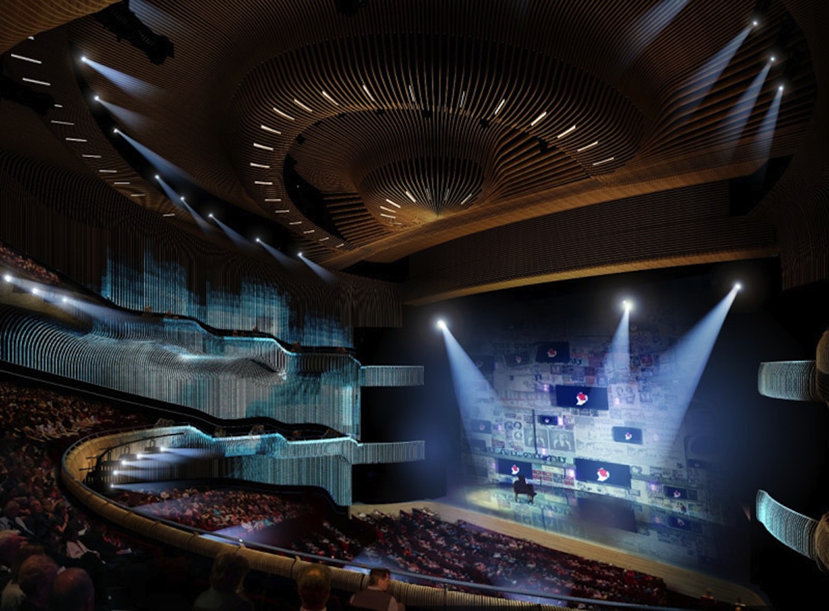 Interior view of Zorlu Performing Arts Center showing a multi-tiered auditorium with curved wooden slat ceiling design