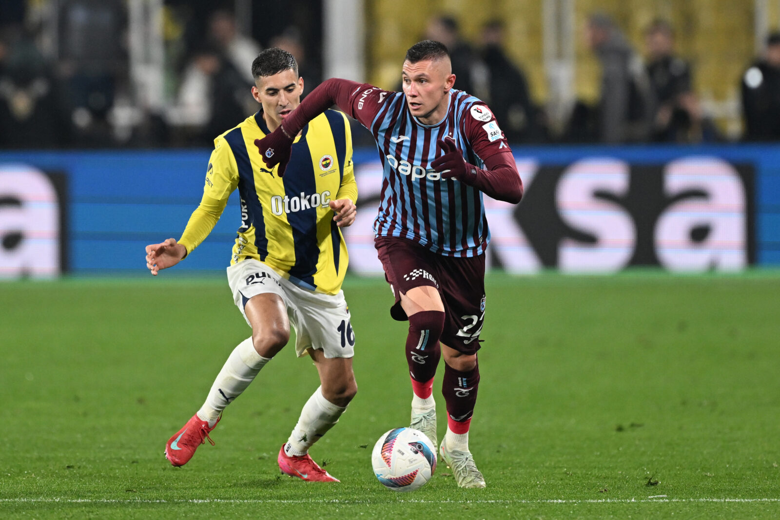 Mert Muldur (L) of Fenerbahce in action against Oleksandr Zubkov (R) of Trabzonspor during the Turkish Super Lig week 30 football match between Fenerbahce and Trabzonspor