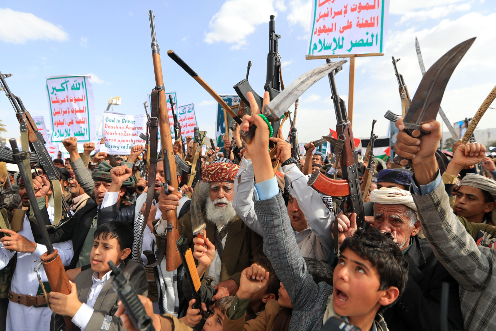 Photo shows armed Yemenis chanting slogans during a rally.